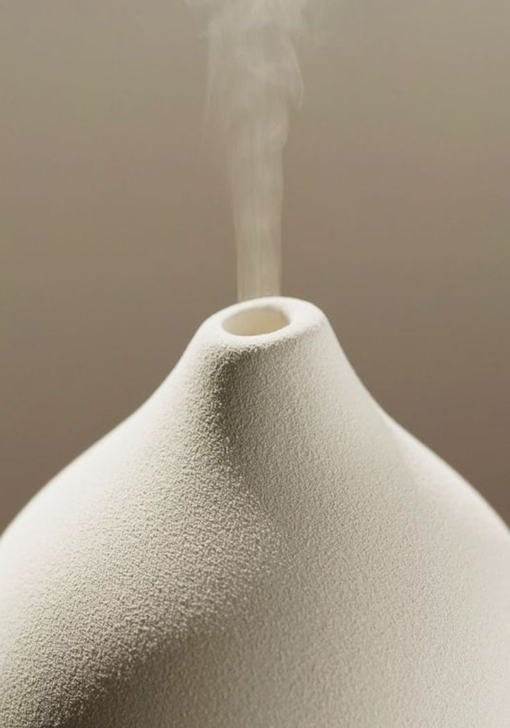 Diffuseur en céramique blanche d’où s’échappe une vapeur parfumée